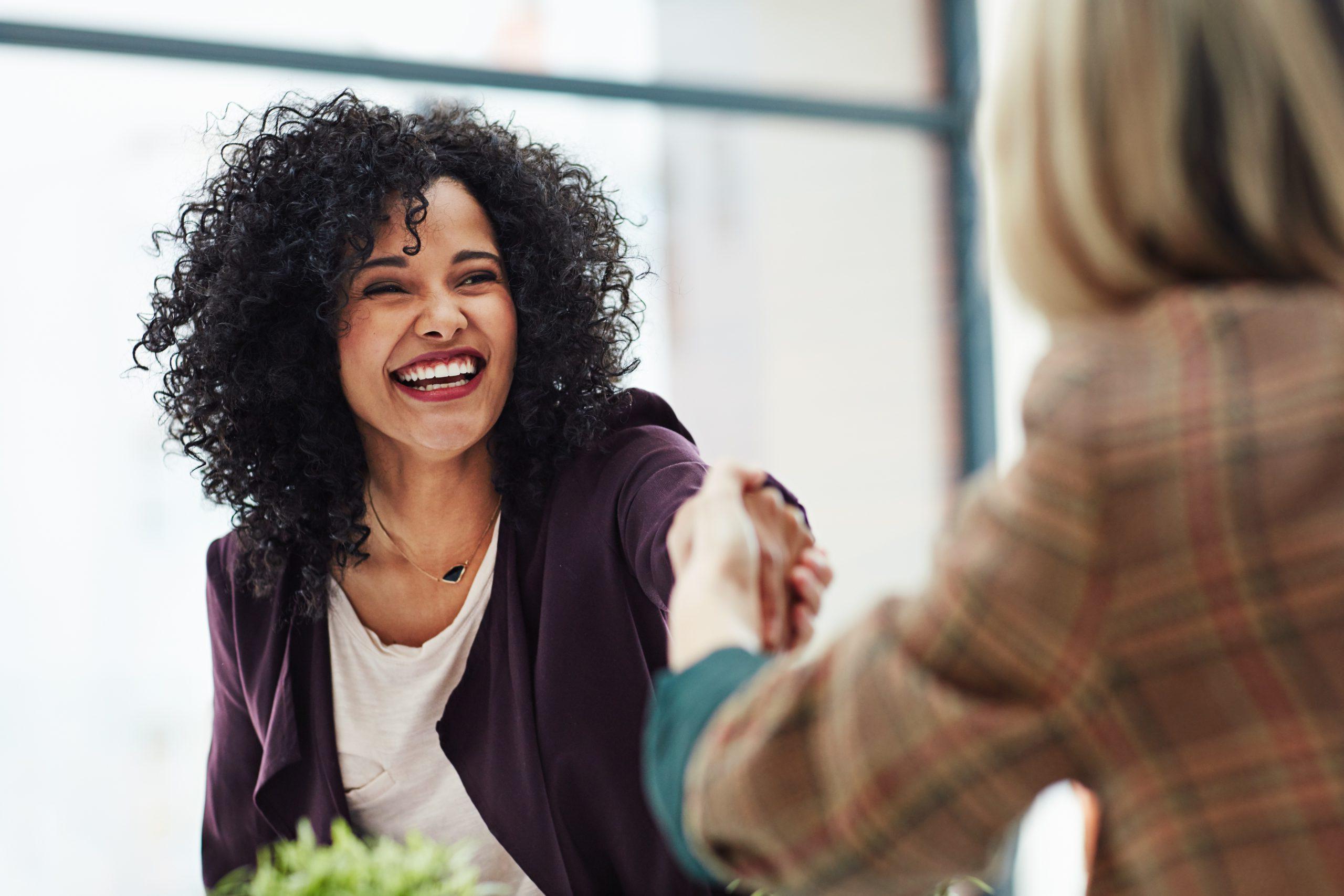 Handshake with a happy, confident and excited business woman